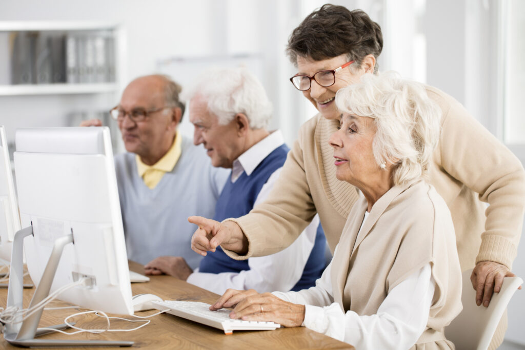 Senior women and men engaging with computers at Vista Prairie at Fieldcrest, Sheldon East 6th Street, a planned senior living community offering assisted living and memory care in Iowa.
