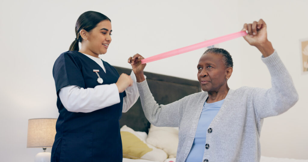 Elderly woman doing physical therapy with senior care nurse using resistance band in assisted living at Vista Prairie at Fieldcrest.