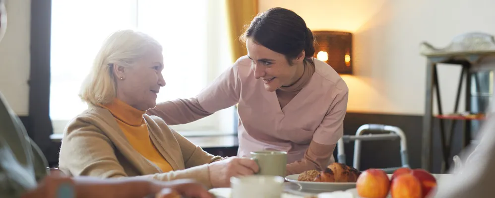 Comfortable elderly woman visiting with caregiver at Vista Prairie senior living community in Sheldon, Iowa.