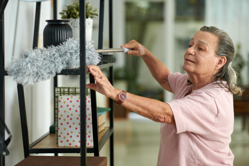 Bright elderly woman engaging in cleaning or organizing activities at Vista Prairie senior living community in Sheldon, Iowa, emphasizing comfortable assisted living and elderly care services.