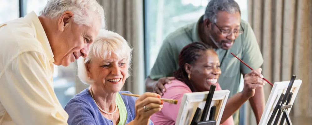 Colorful seniors enjoying an engaging painting activity at Vista Prairie at Windmill Ponds in Alexandria, MN, encouraging community, creativity, and active senior living.