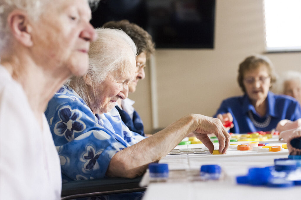 Friendly seniors playing a colorful board game during activity at Vista Prairie senior living in Alexandria, MN.