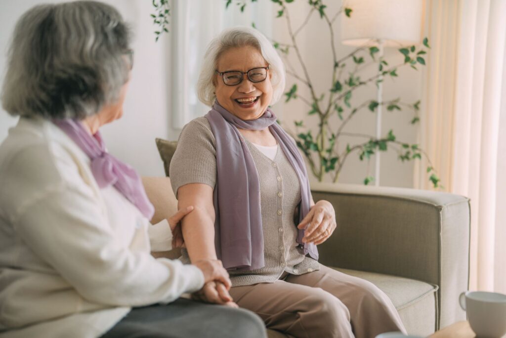 picture of two older women smiling at one another