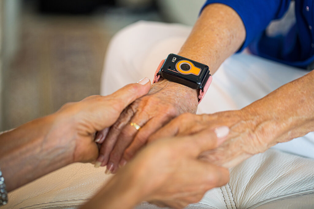 Emergency response smartwatch on an elderly resident's wrist at Vista Prairie at Goldfinch Estates senior living community in Fairmont, Minnesota.