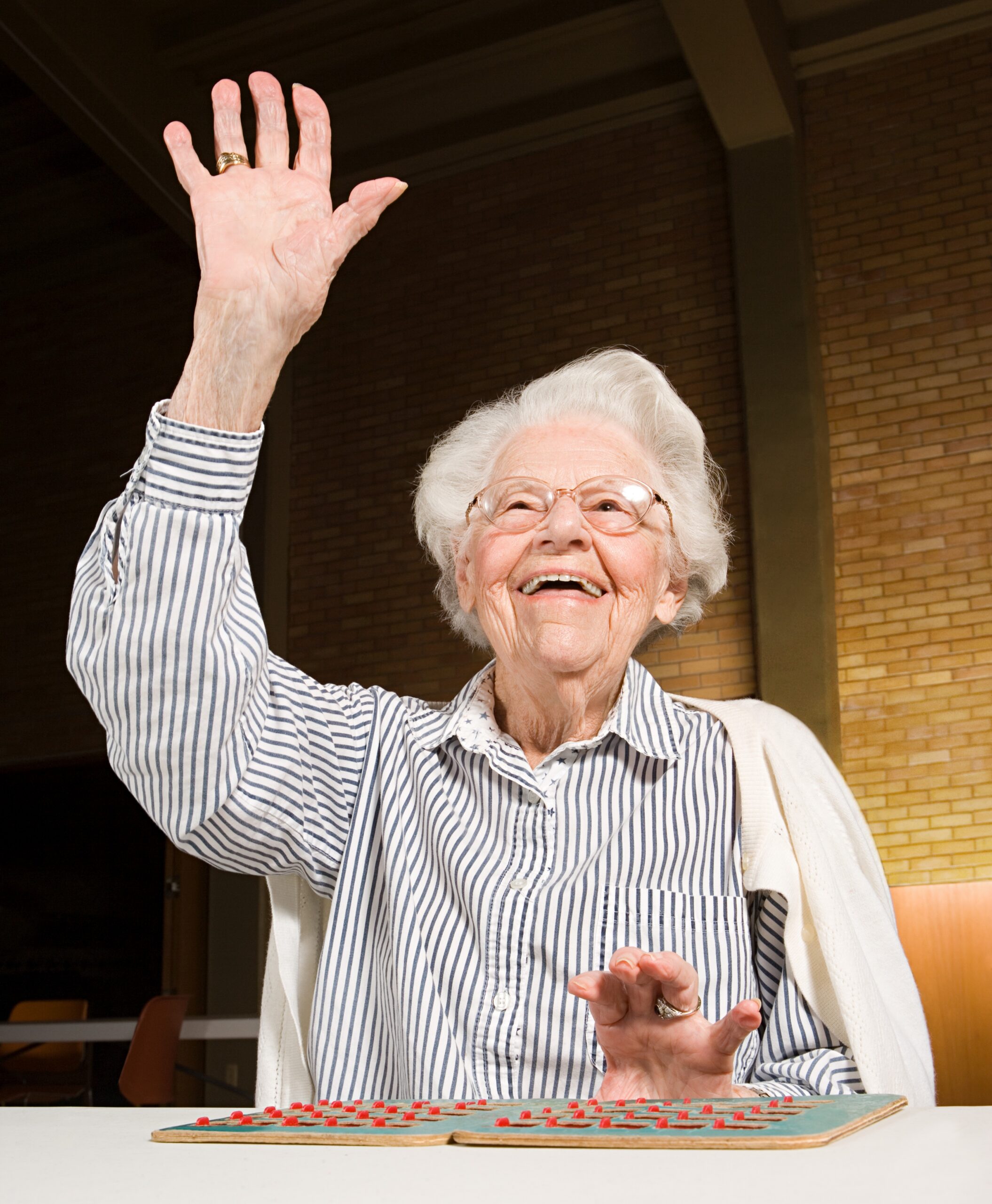 picture of an older woman raising her hand for a bingo