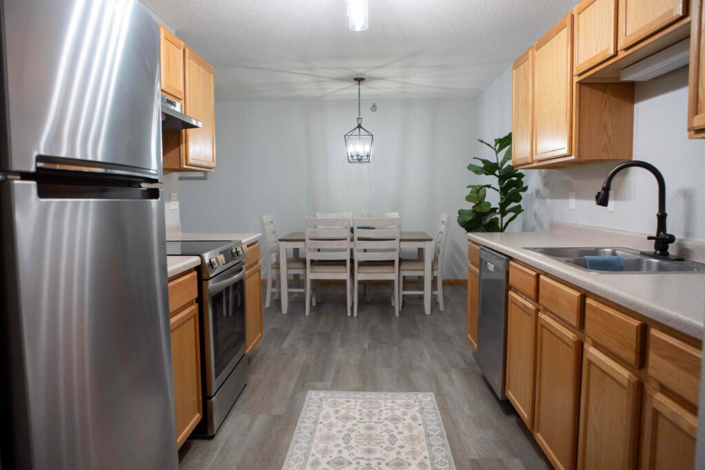 Modern senior living apartment kitchen at Vista Prairie North Pointe in North Mankato, MN with updated appliances and cozy dining area.