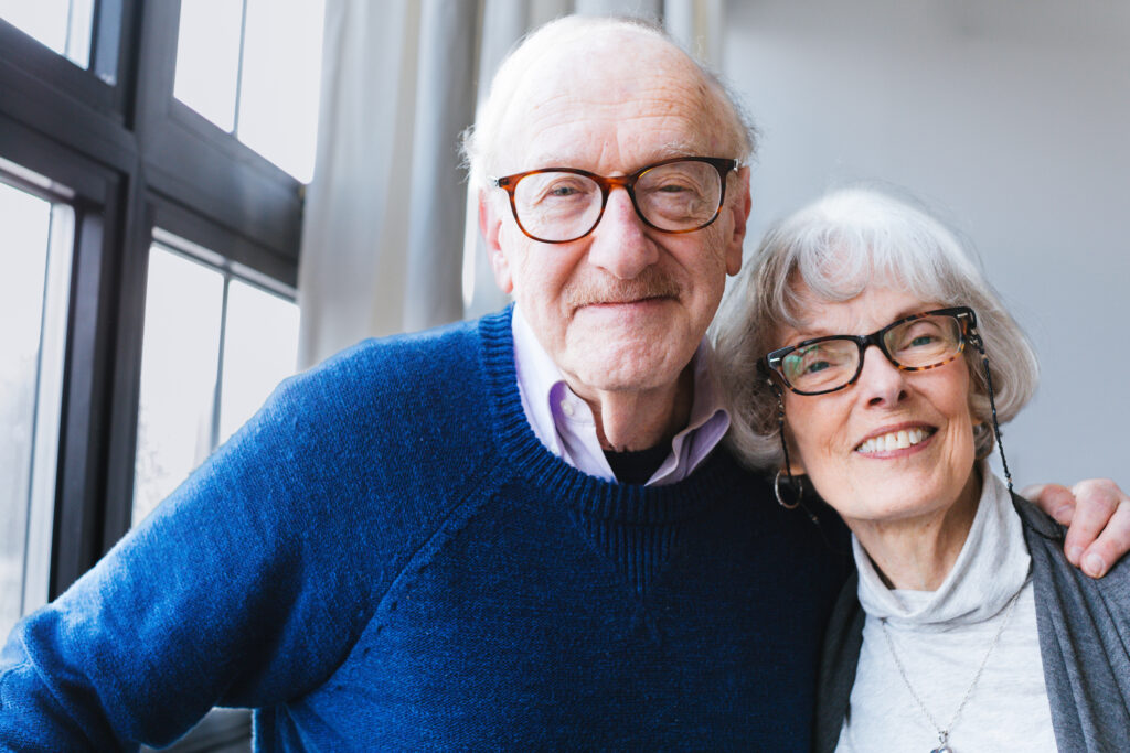 Warm elderly couple smiling together at Vista Prairie North Pointe senior living community in North Mankato, Minnesota.