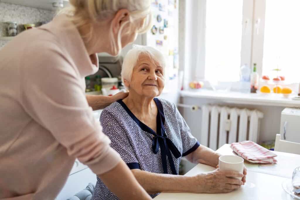 picture of woman talking to her senior mother sitting at a table