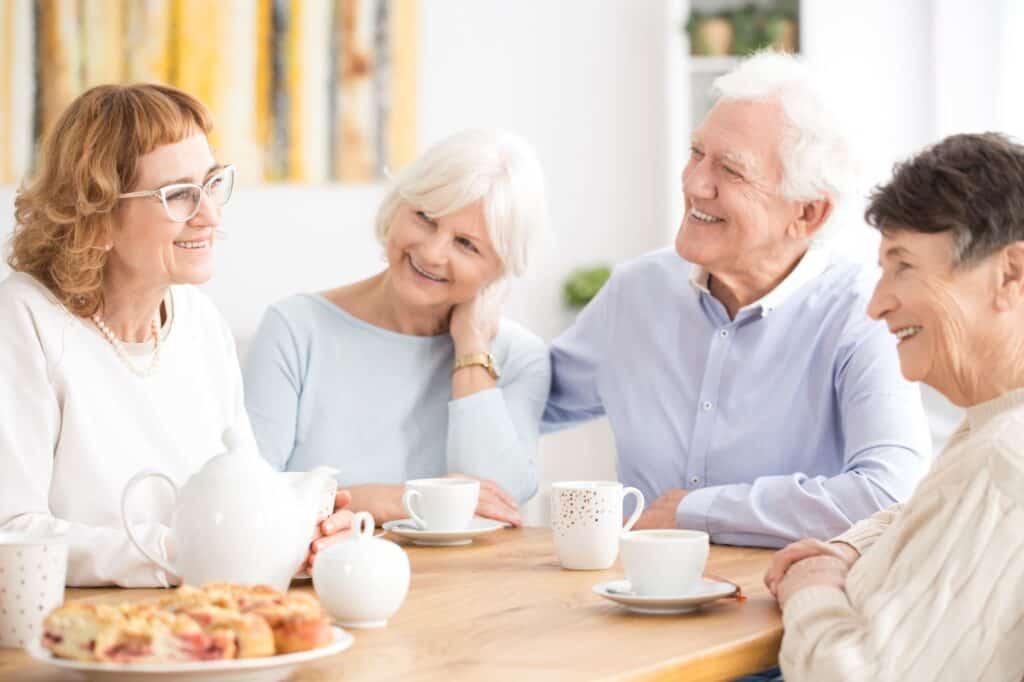 Group of elderly friends enjoying coffee and conversation at a senior living community in St. Francis, Minnesota.