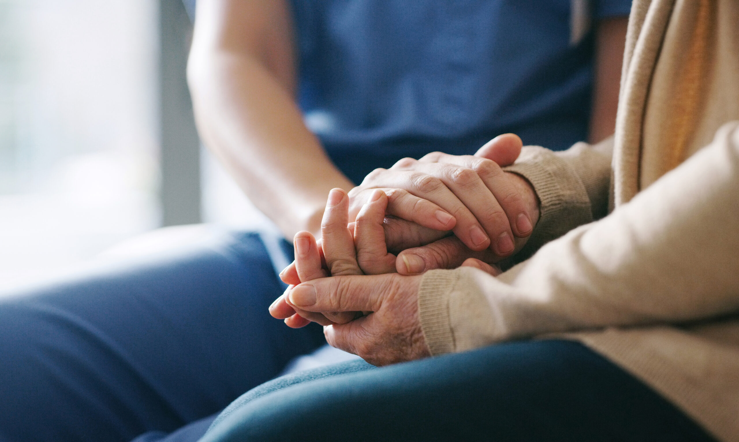 picture of a caregiver holding hands with an older adult