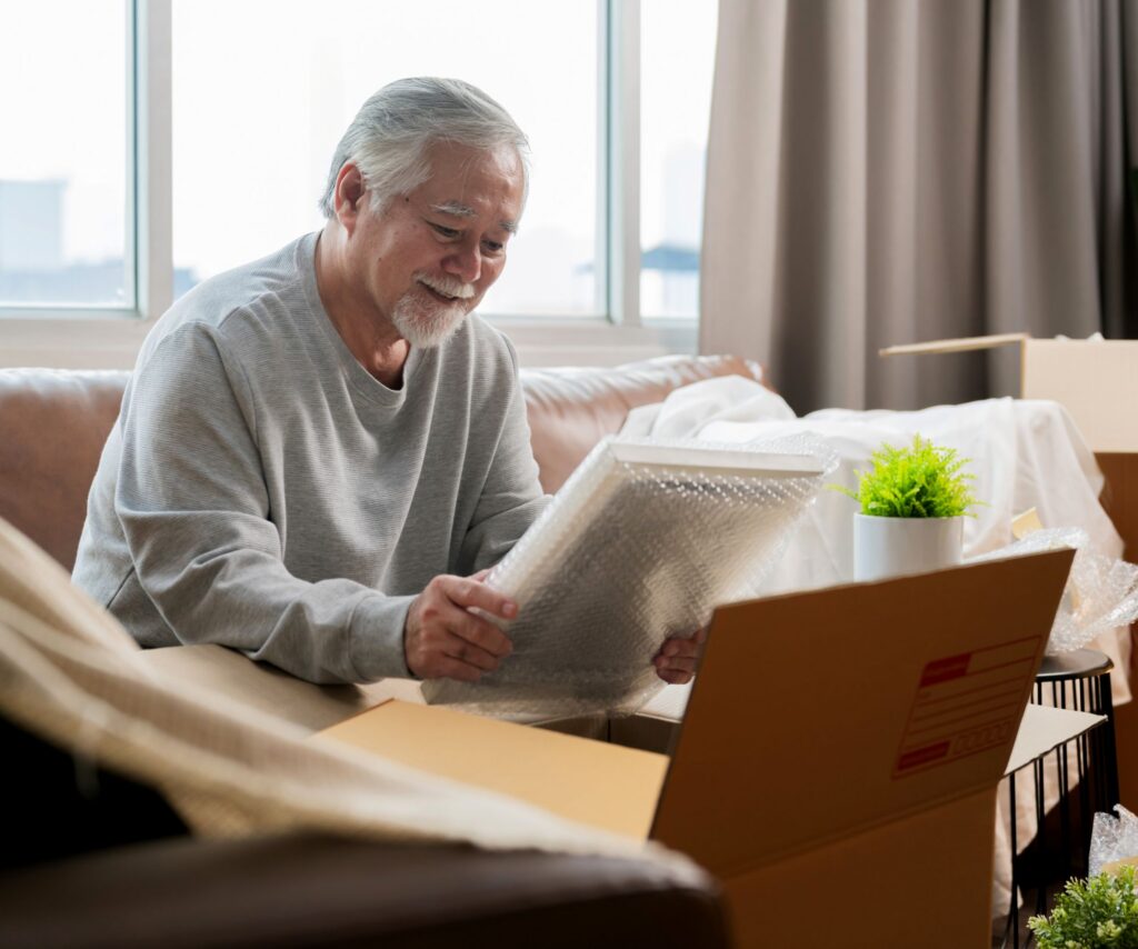 picture of a man looking at photo frame while surrounded by moving boxes