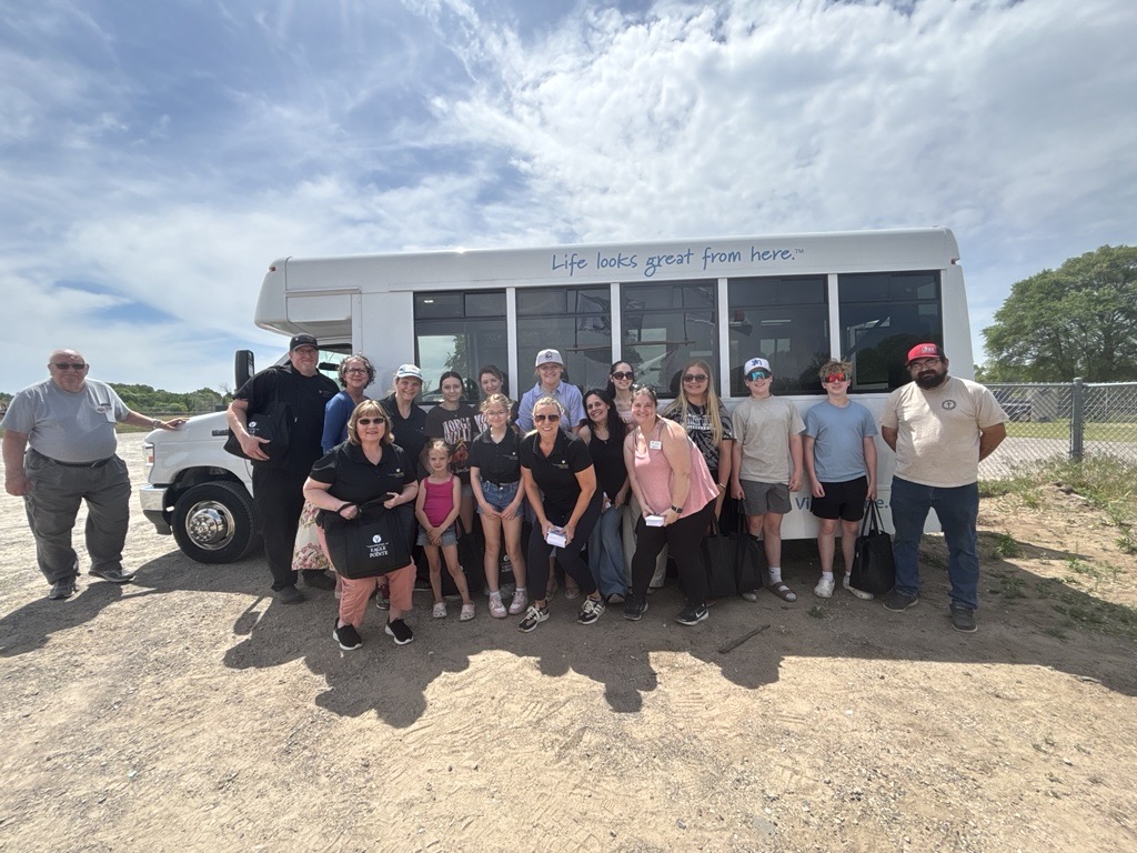 picture of a group in front of a Vista Prairie Communities bus
