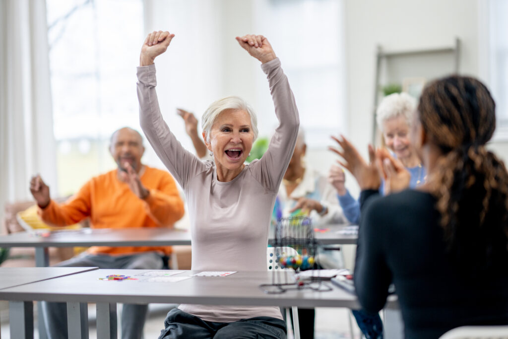 Mature woman raising her hands in excitement after yelling bingo