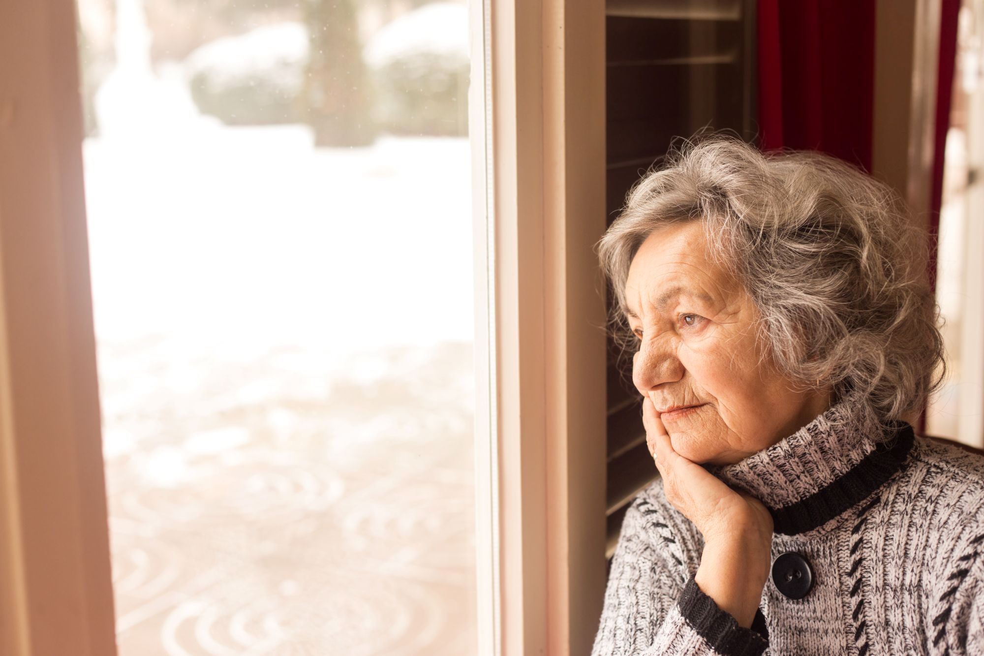 picture of an older woman looking out the window