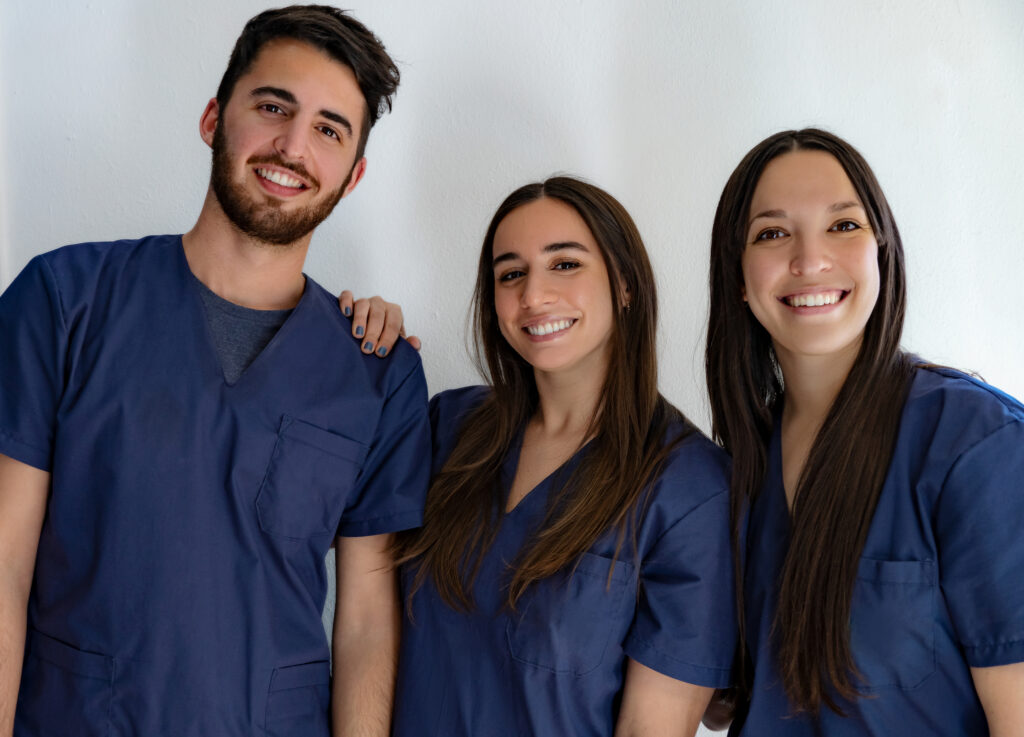 group of 3 people in scrubs smiling at camera